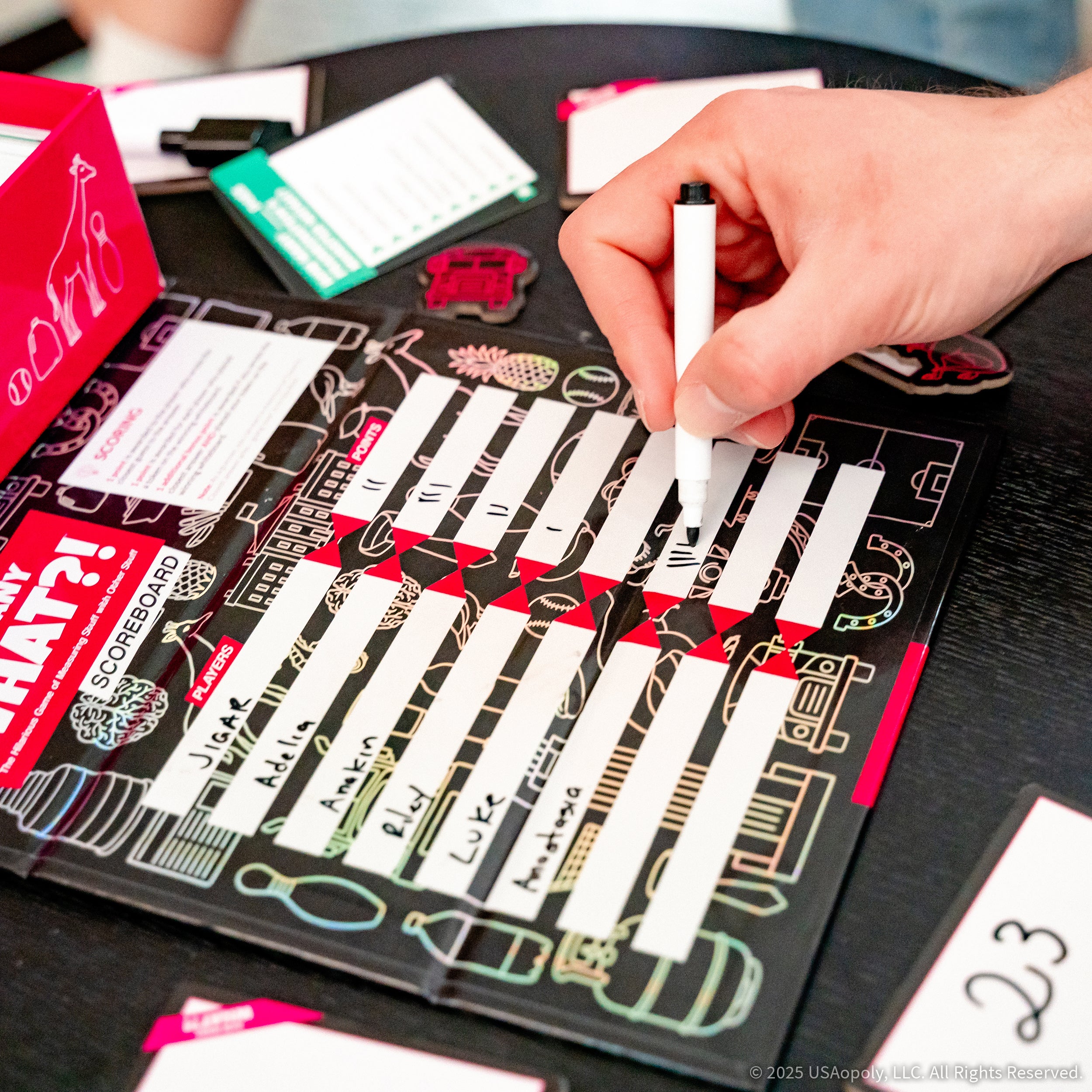 Player writing points on the How Many What scoreboard