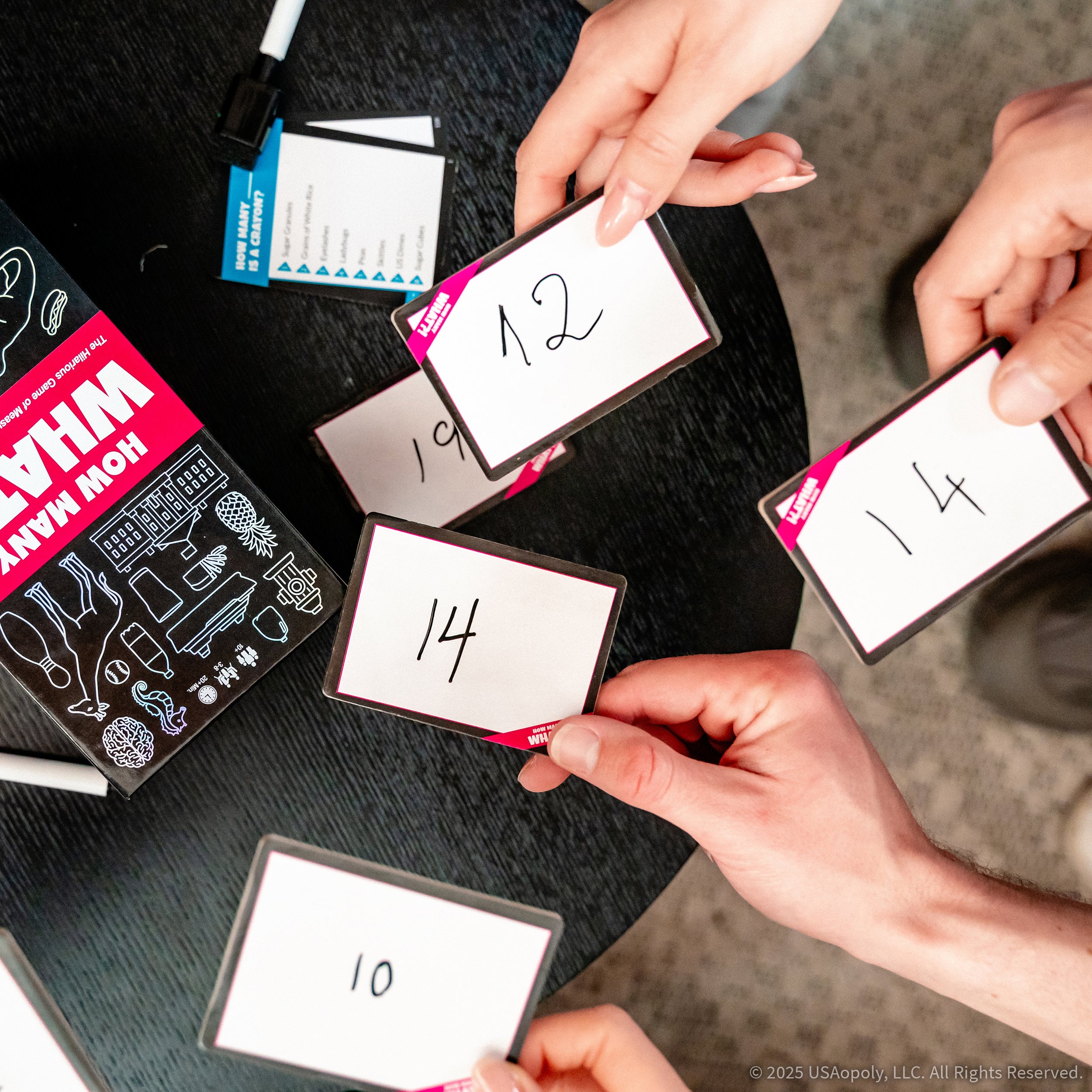Four players revealing numbered whiteboards around the game