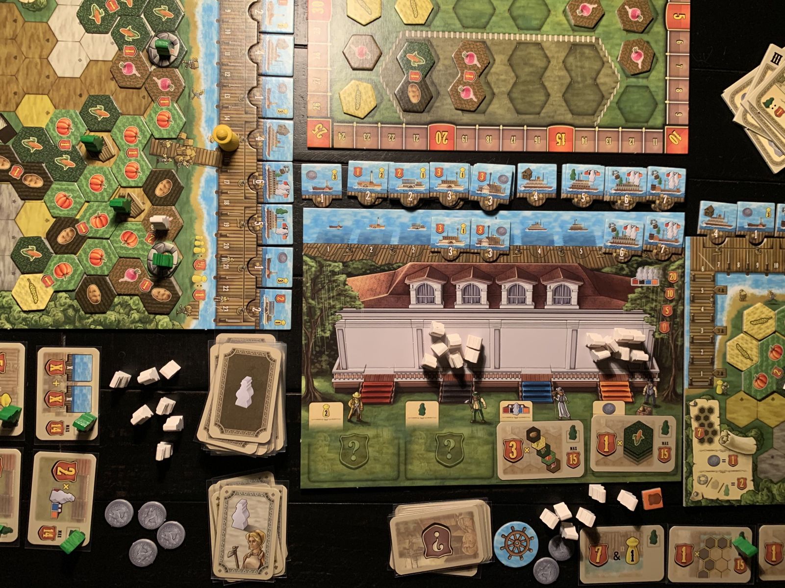 Riverboat board game in progress with personal farms and central boards