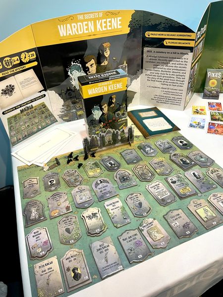 The Secrets of Warden Keene displayed at a board game convention