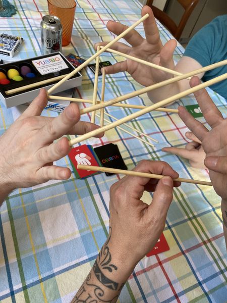 Players balancing YUBIBO sticks between fingers