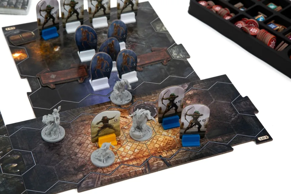 Close view of a Gloomhaven tabletop scenario with map tiles, miniatures, cards, and tokens