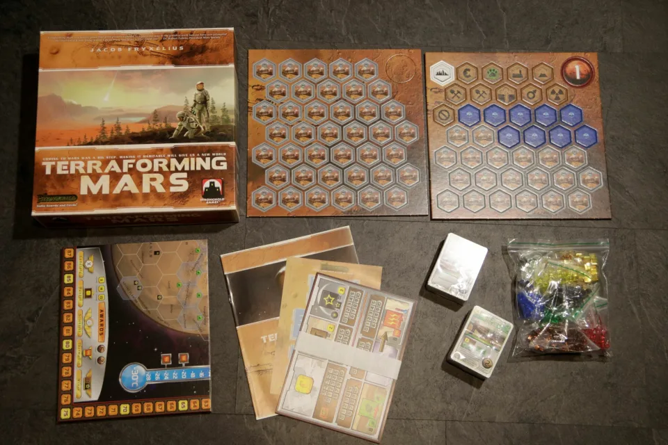 Terraforming Mars base-game board, player boards, cards, markers, tiles, rulebooks, and box arranged together