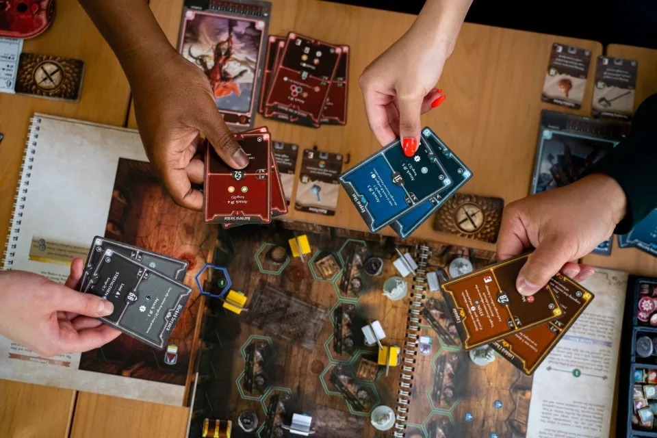 Gloomhaven Jaws of the Lion scenario set up with book map, cards, standees, and player materials