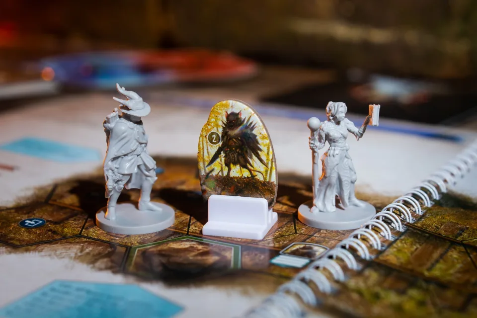 Gloomhaven Jaws of the Lion miniatures and enemy standee on the spiral-bound scenario book map