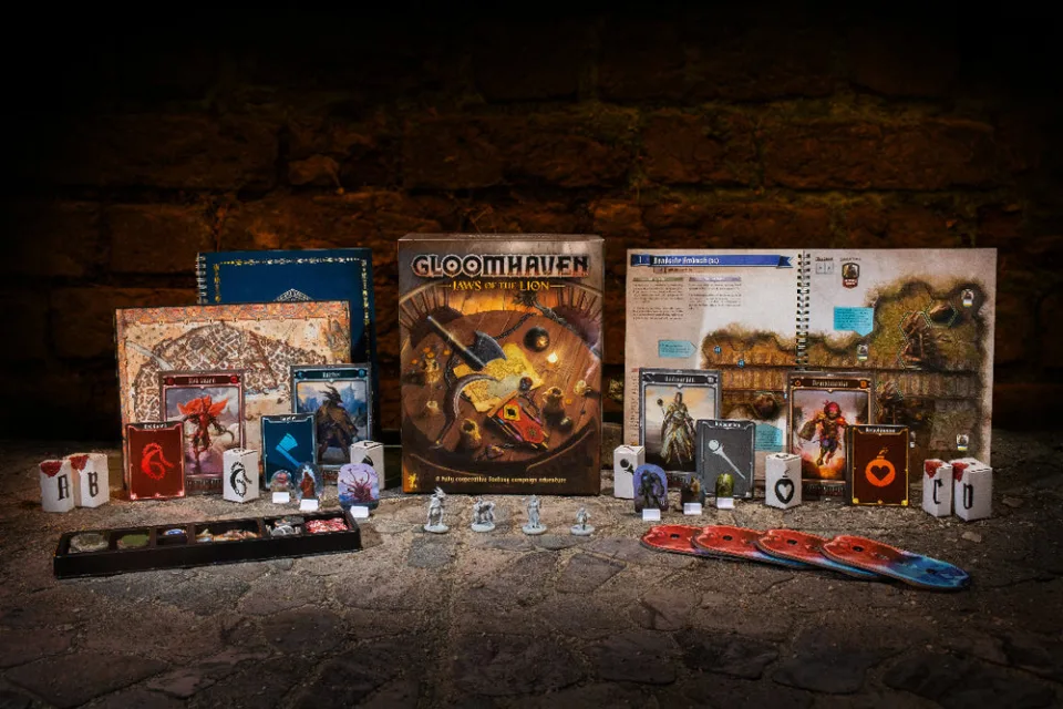 Gloomhaven Jaws of the Lion box, scenario book, character materials, standees, miniatures, dice, and token tray