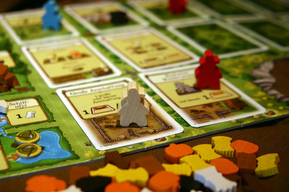 Close-up of Agricola action cards and wooden player pieces.