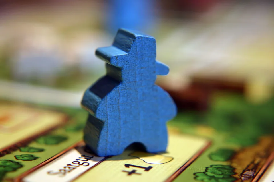 Blue wooden Agricola family member on a player board.