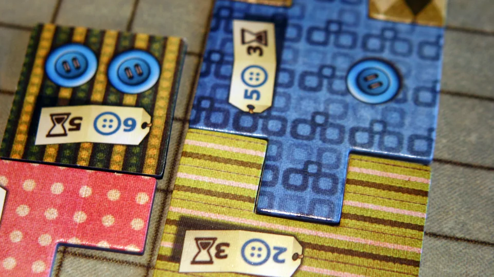 Close-up of Patchwork quilt boards, patch pieces, buttons, and time costs.