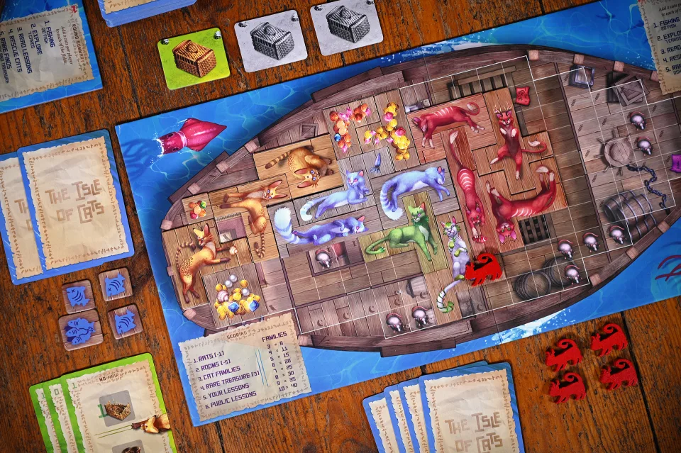 The Isle of Cats player boat filled with cat tiles, treasures, cards, fish tokens, and rat spaces.