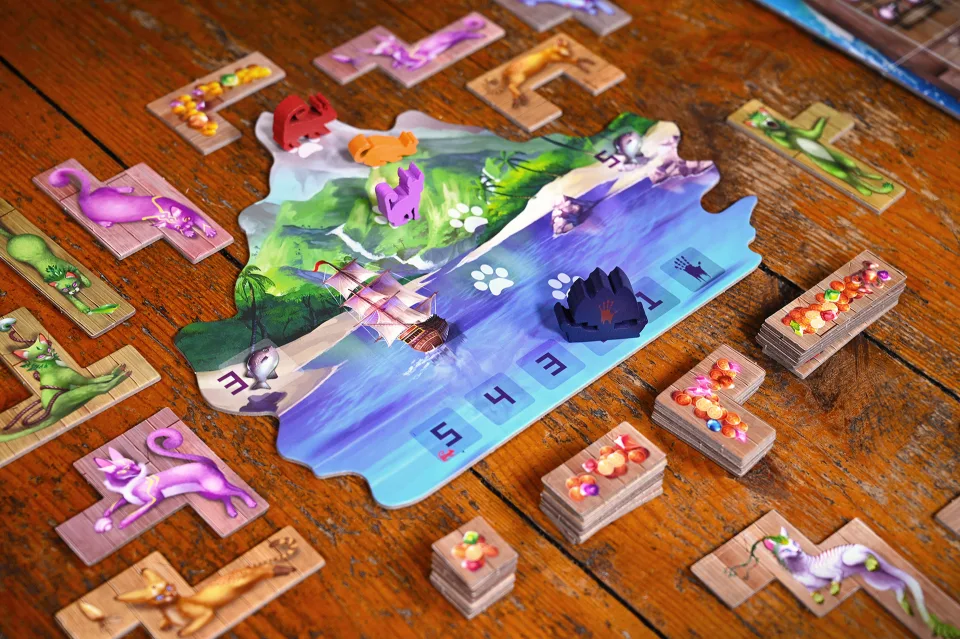 The Isle of Cats island board, rescue boat, cat tiles, baskets, fish, and treasure tiles in play.