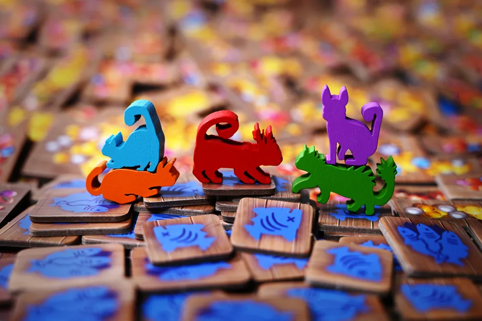 The Isle of Cats colored wooden cat figures and fish tokens.