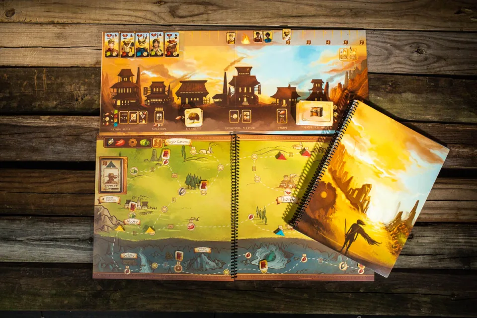 Near and Far game setup with town board and open spiral-bound map book.