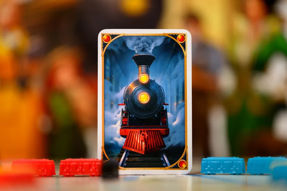Ticket to Ride locomotive card with miniature train pieces